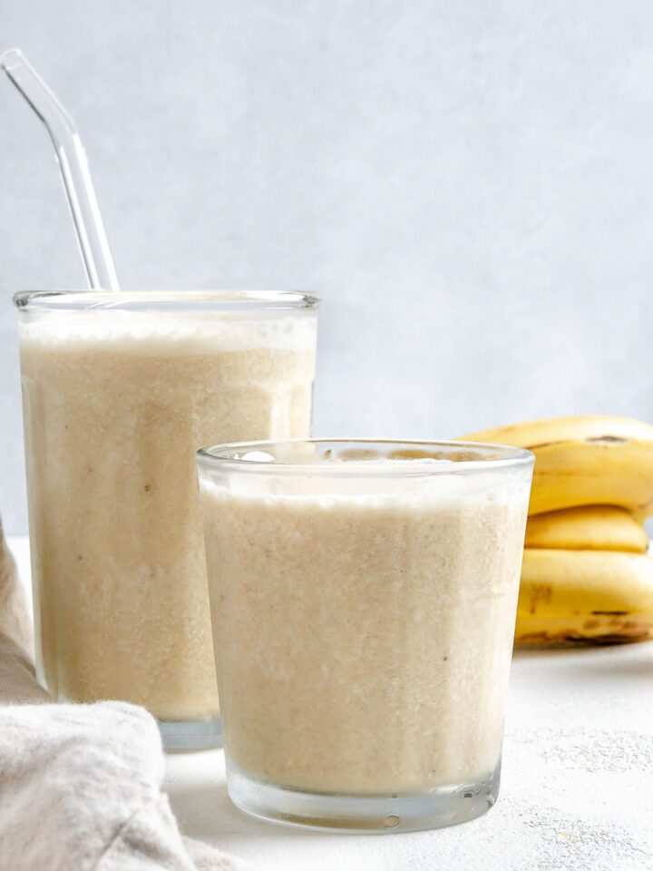 completed Banana Milkshake in two glass cups against a white background