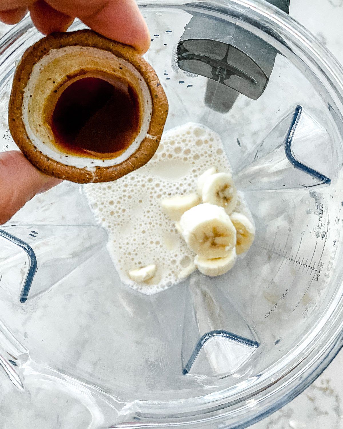 process of adding vanilla to blender for banana milkshake