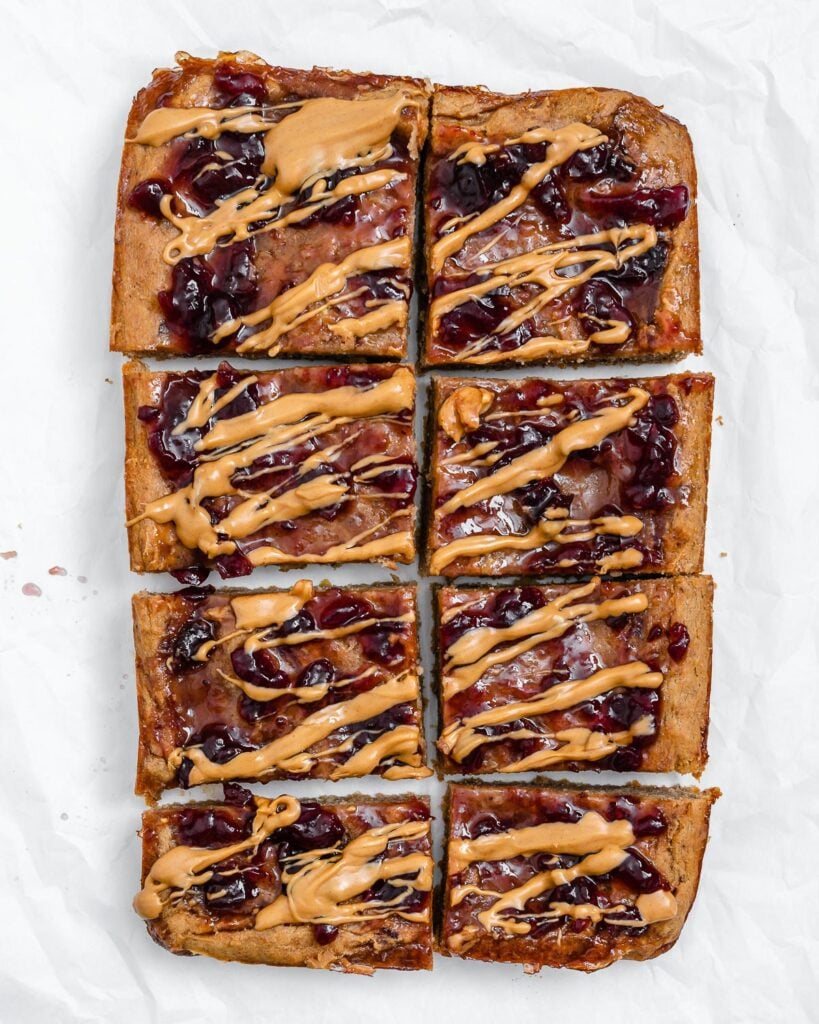 completed and sliced Peanut Butter and Jelly Blondie Bars on a white surface