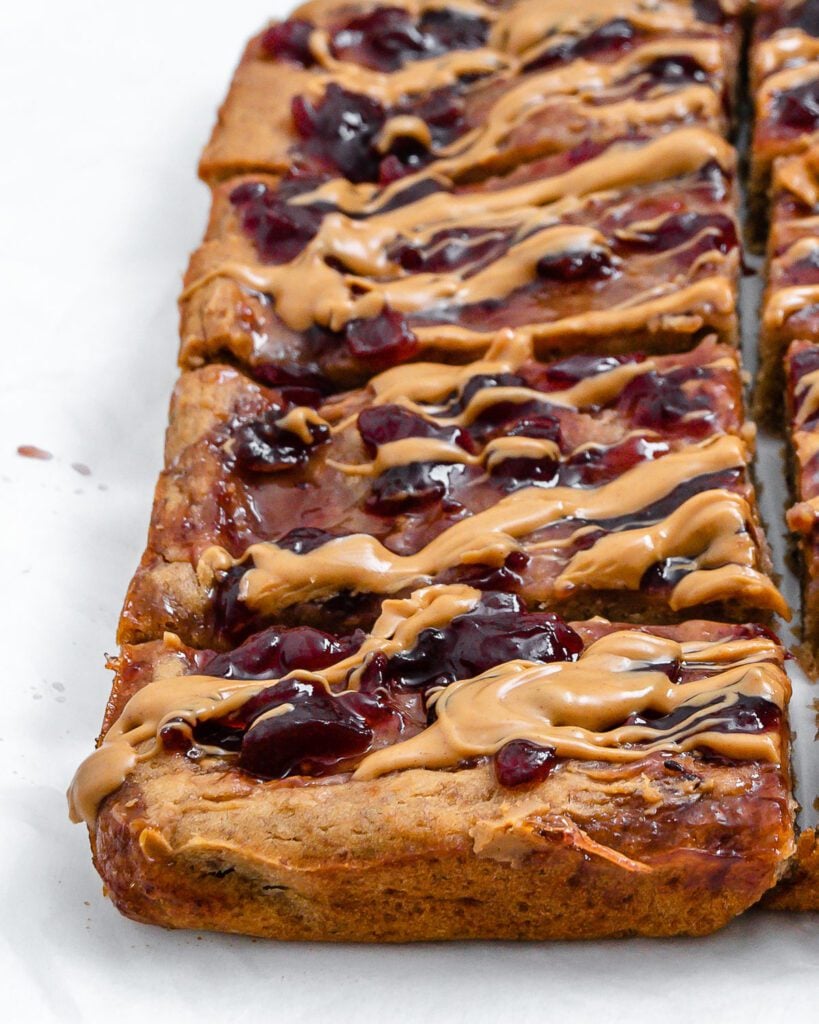 completed and sliced Peanut Butter and Jelly Blondie Bars on a white surface