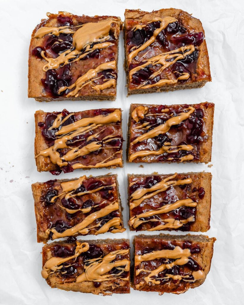 completed and sliced Peanut Butter and Jelly Blondie Bars on a white surface