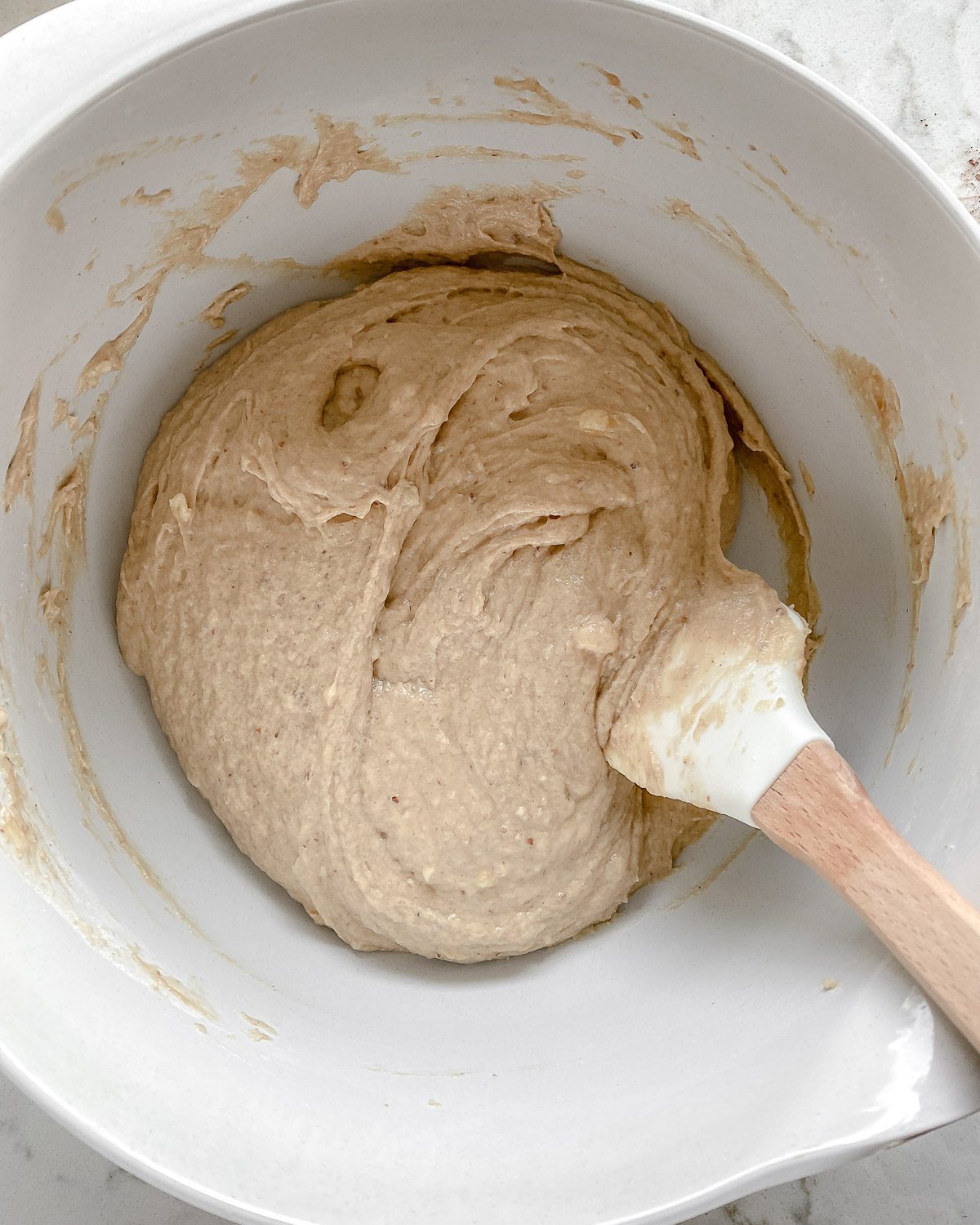process of mixing batter for Peanut Butter and Jelly Blondie Bars in a white bowl