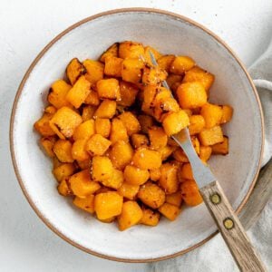 completed Simple Air Fryer Butternut Squash in a white bowl with a utensil in the bowl