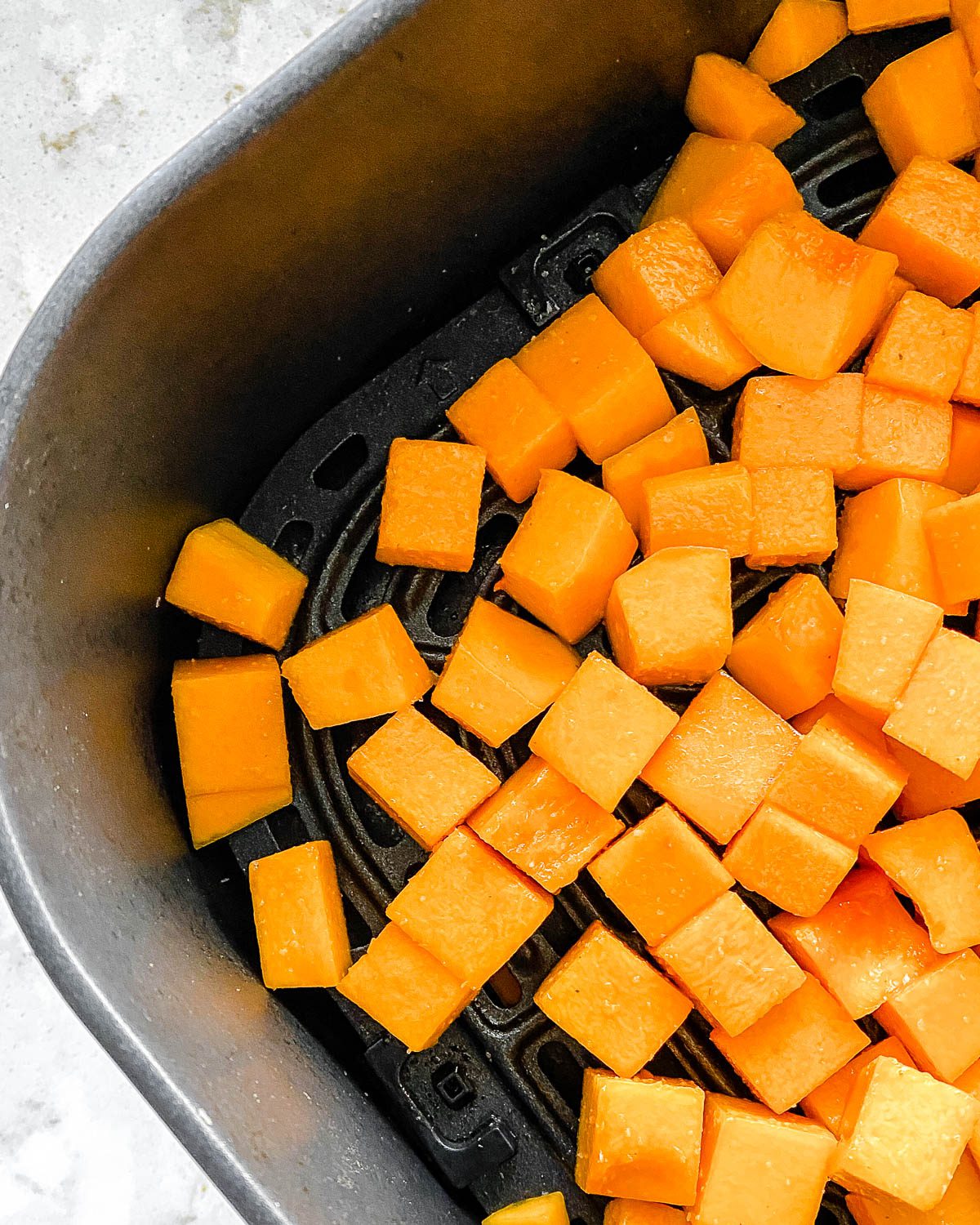 pre-cooked Simple Air Fryer Butternut Squash laid out in an air fryer basket