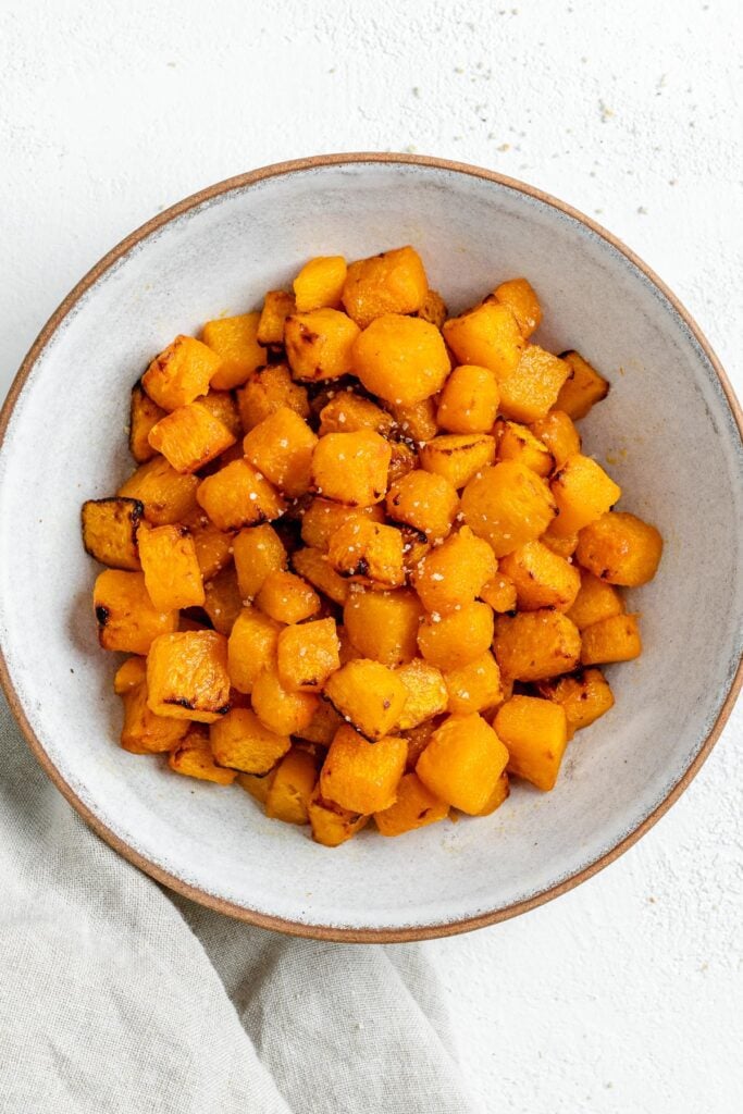 completed Simple Air Fryer Butternut Squash in a white bowl against a white background