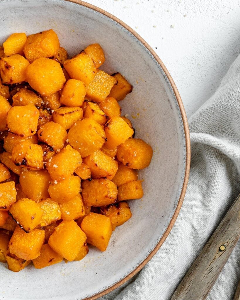 completed Simple Air Fryer Butternut Squash in a white bowl against a white background