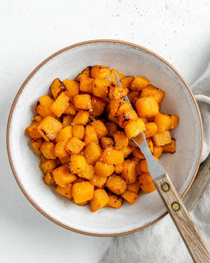 completed Simple Air Fryer Butternut Squash in a white bowl with a utensil in the bowl