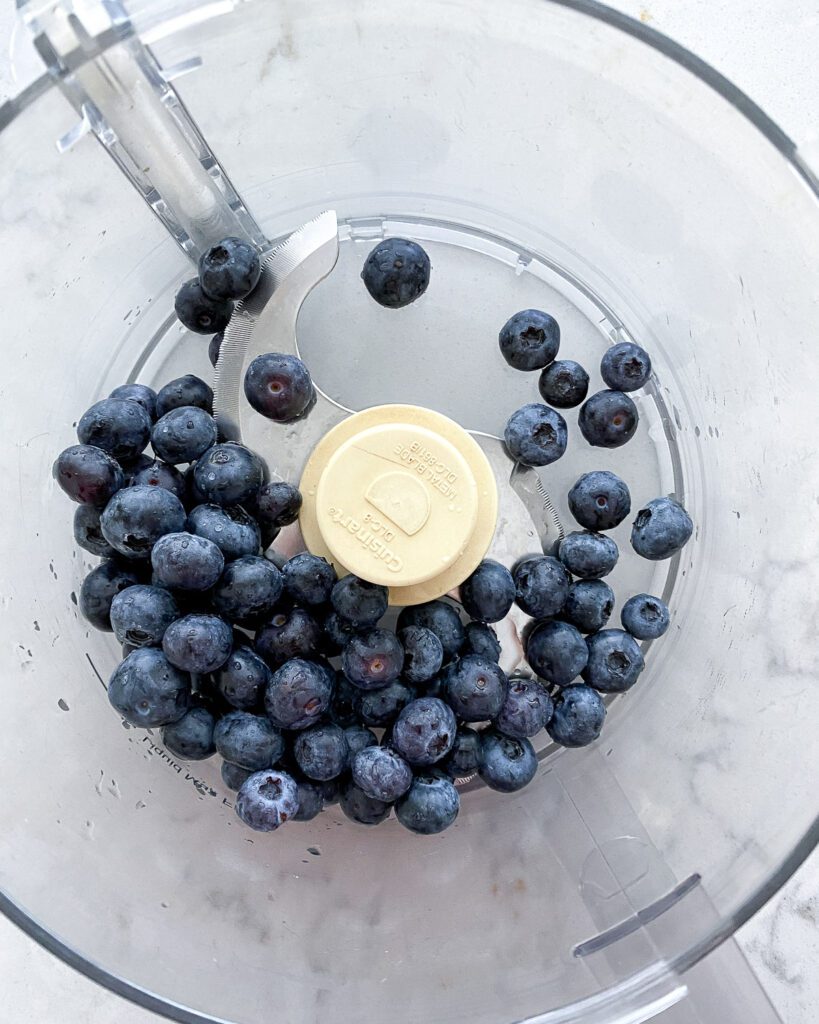 process of adding blueberries to blender