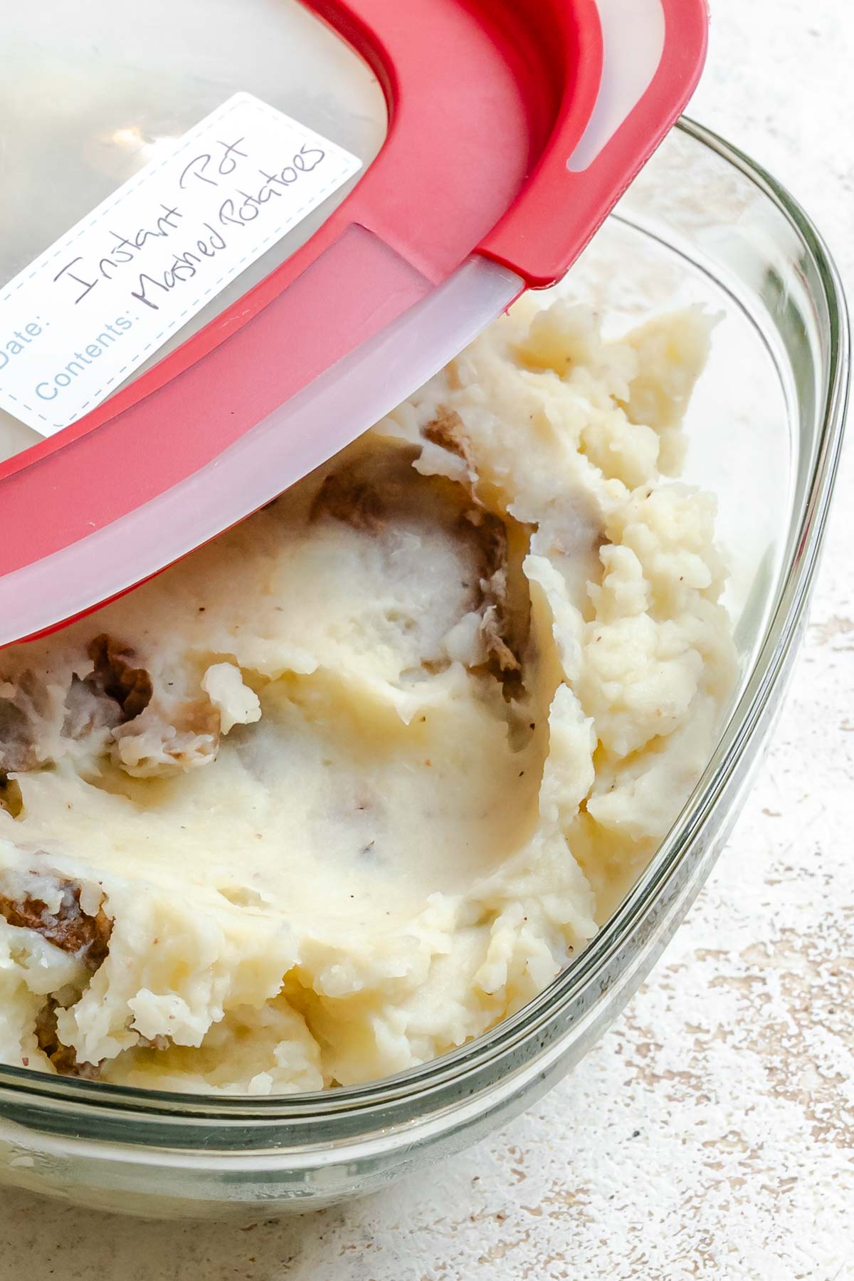 Completed Instant Pot Garlic Mashed Potatoes [+ Mix-Ins] in a storage container.