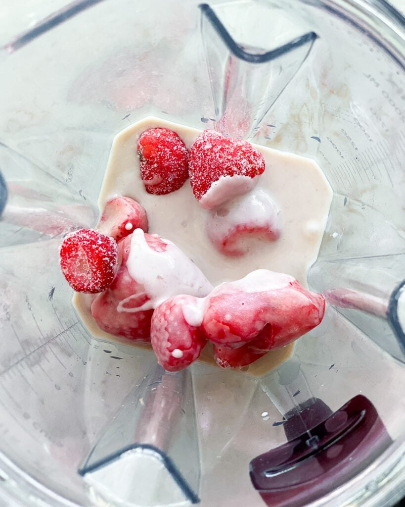 process of adding ingredients for strawberry yogurt smoothie in blender