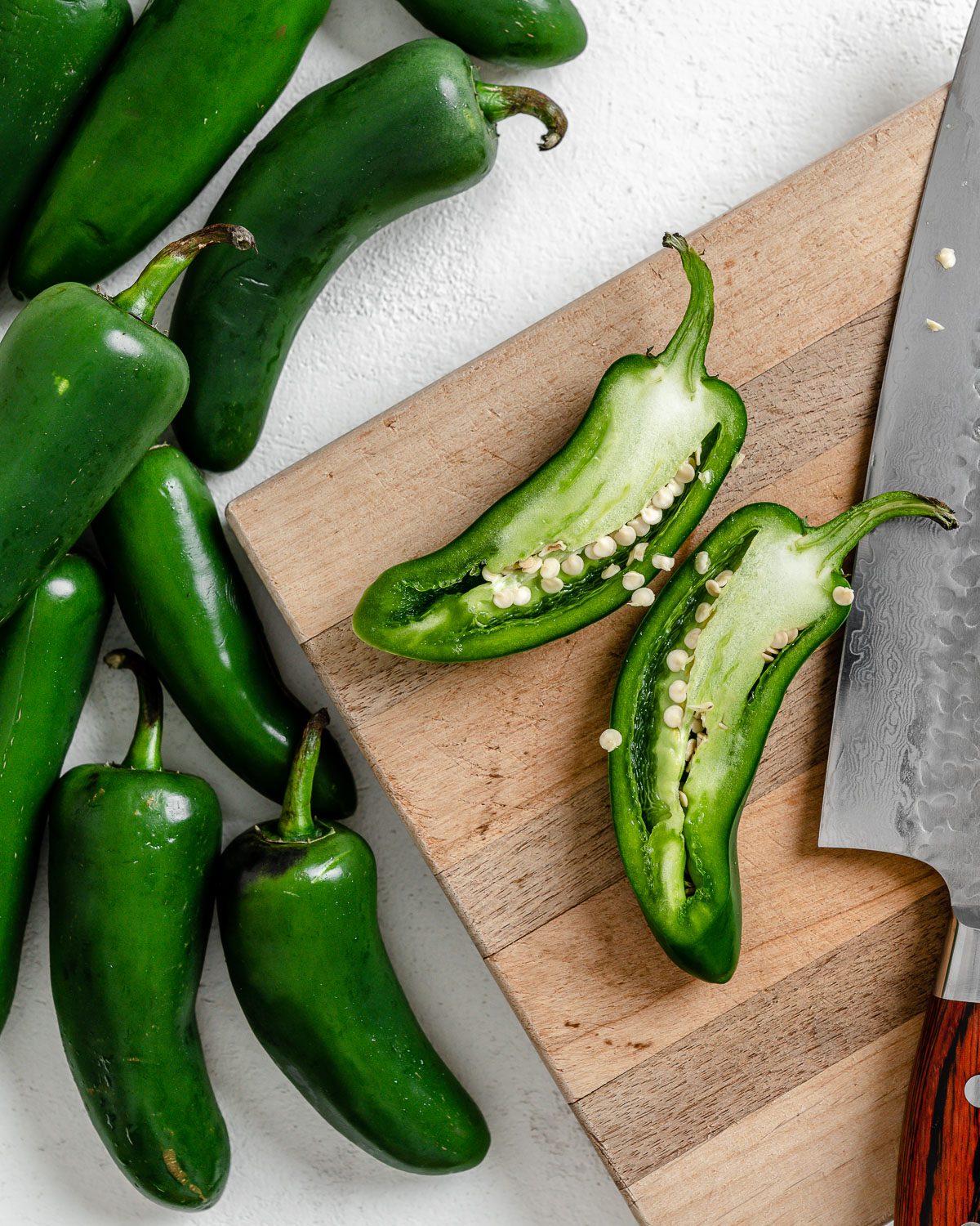 process of de-seeding jalapenos onto a cutting board