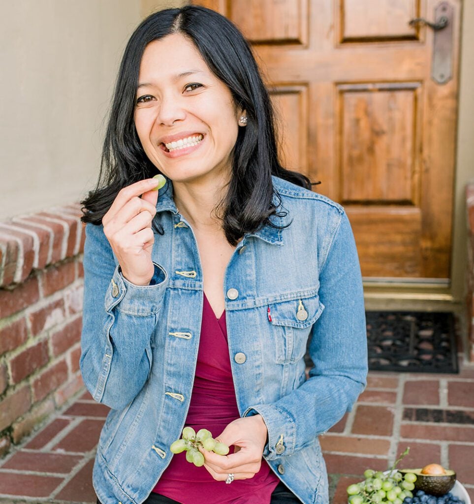 Toni Okamoto sitting on a porch eating grapes