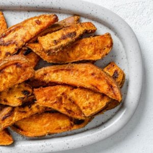 completed sweet potato wedges on a white platter