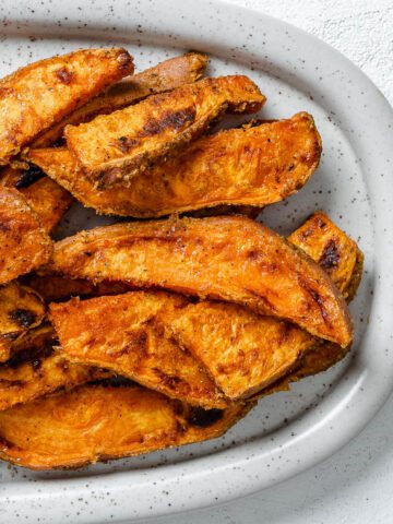 completed sweet potato wedges on a white platter