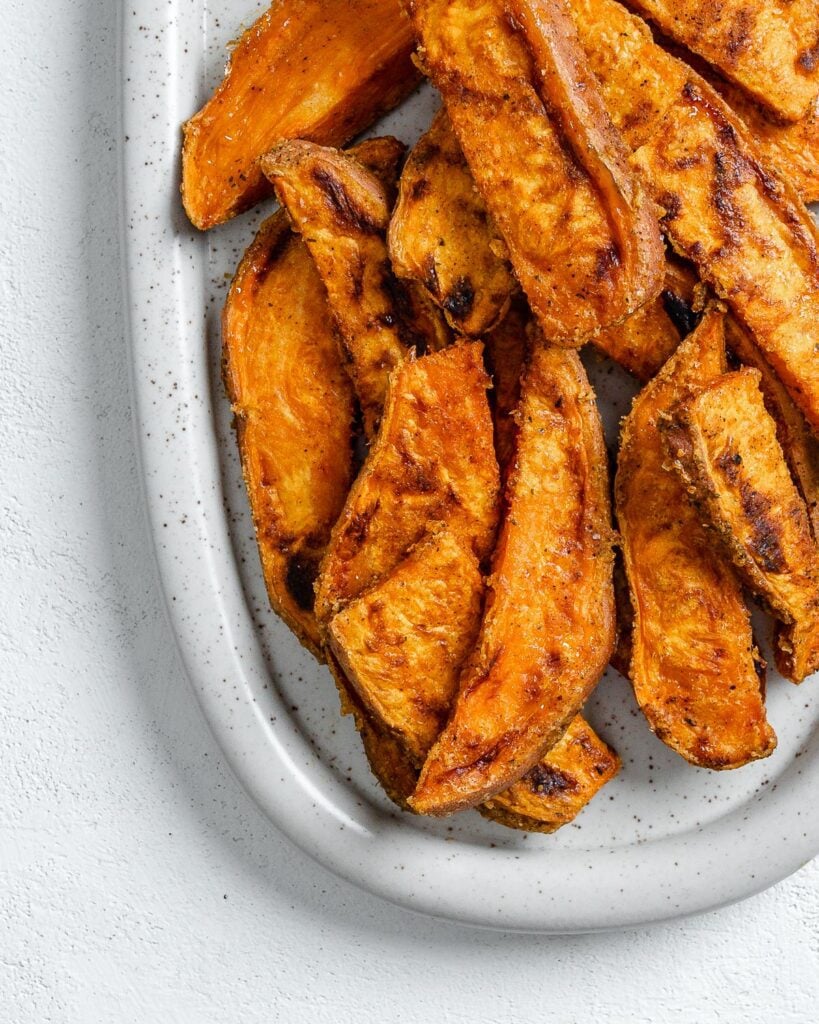 completed sweet potato wedges on a white platter