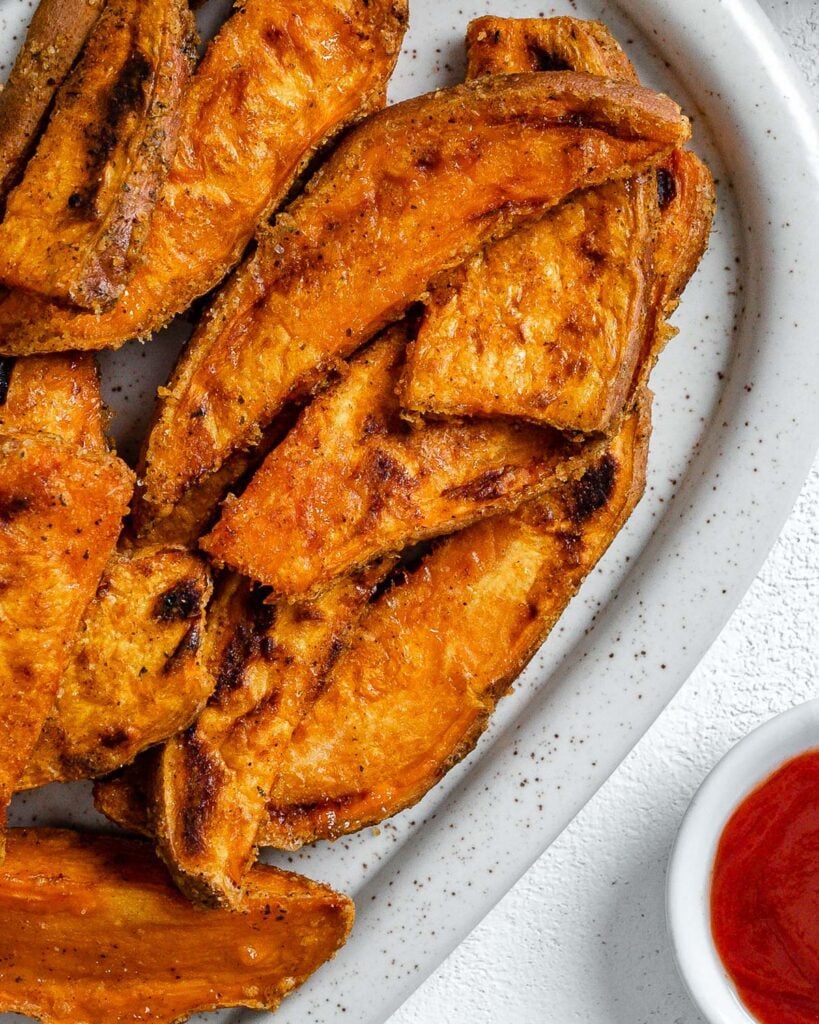 completed sweet potato wedges on a white platter