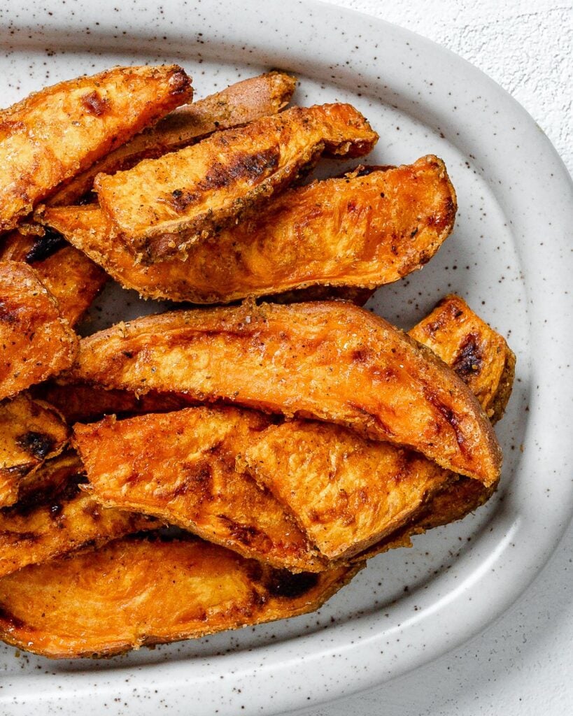 completed sweet potato wedges on a white platter