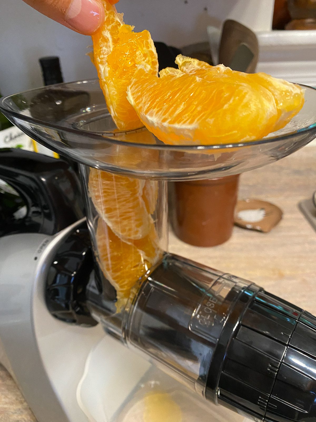 process of adding oranges to juicer
