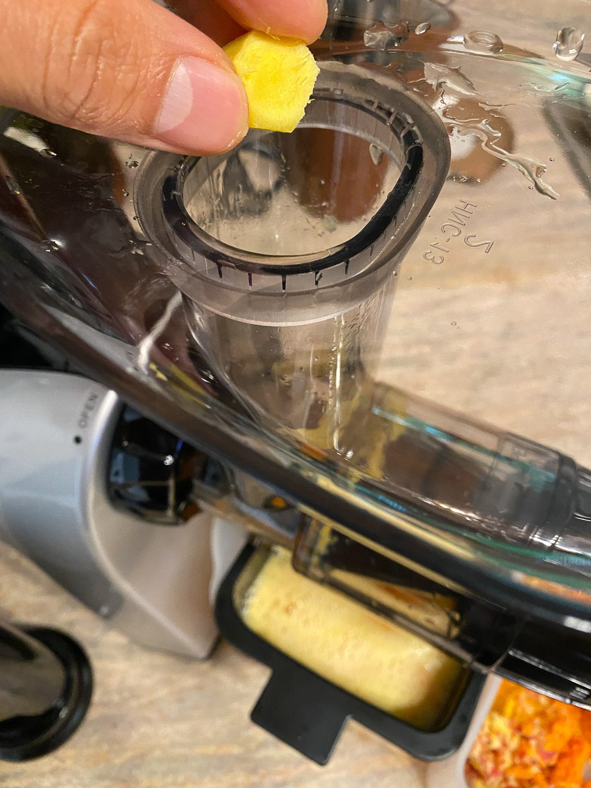 process shot of adding ginger to juicer