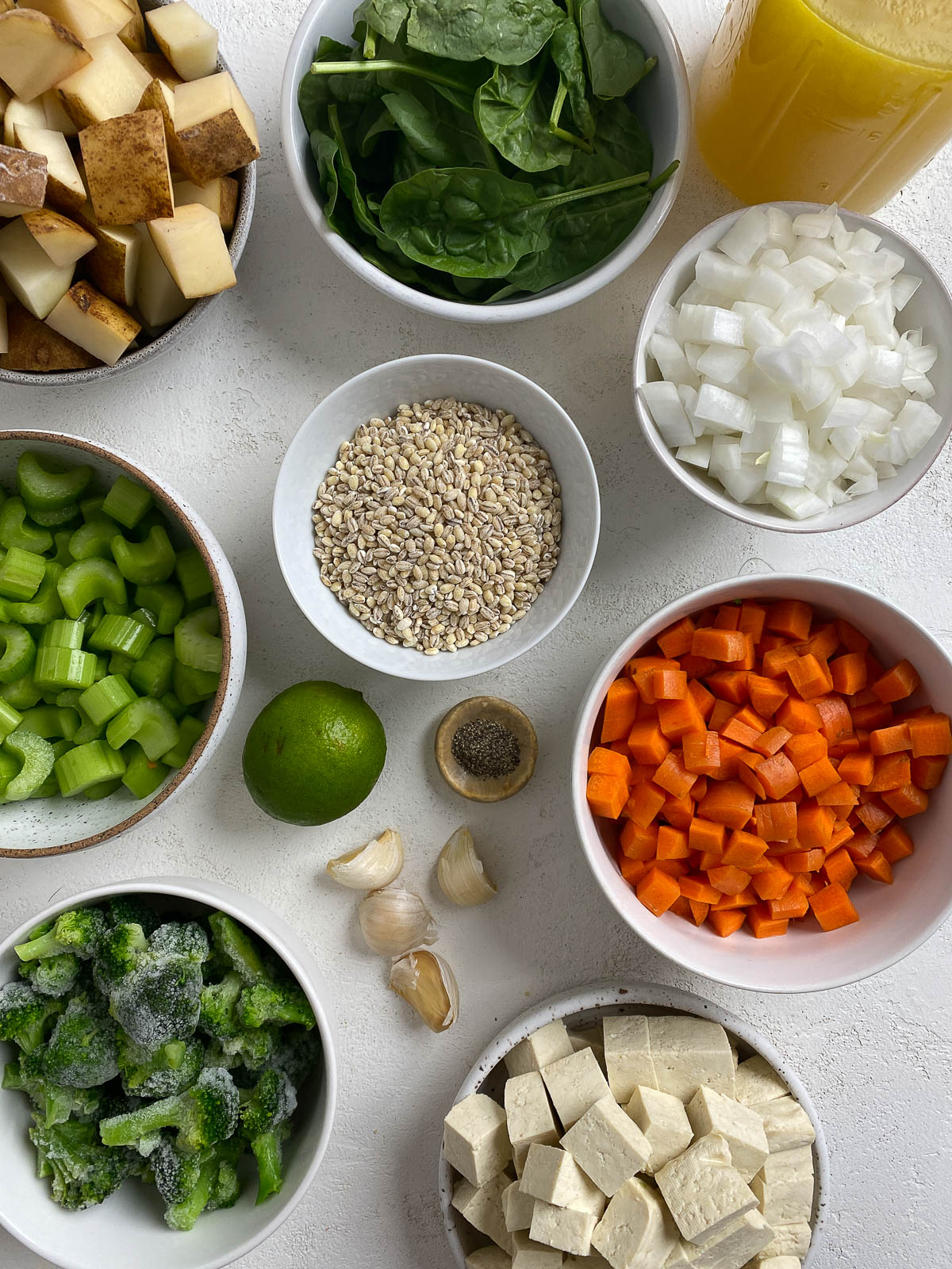 ingredients for Instant Pot Vegetable Barley Soup measured out against a white background