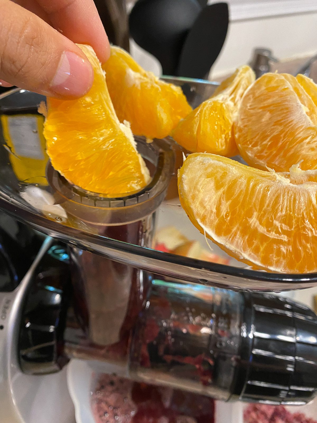 process shot of putting orange into a juicer
