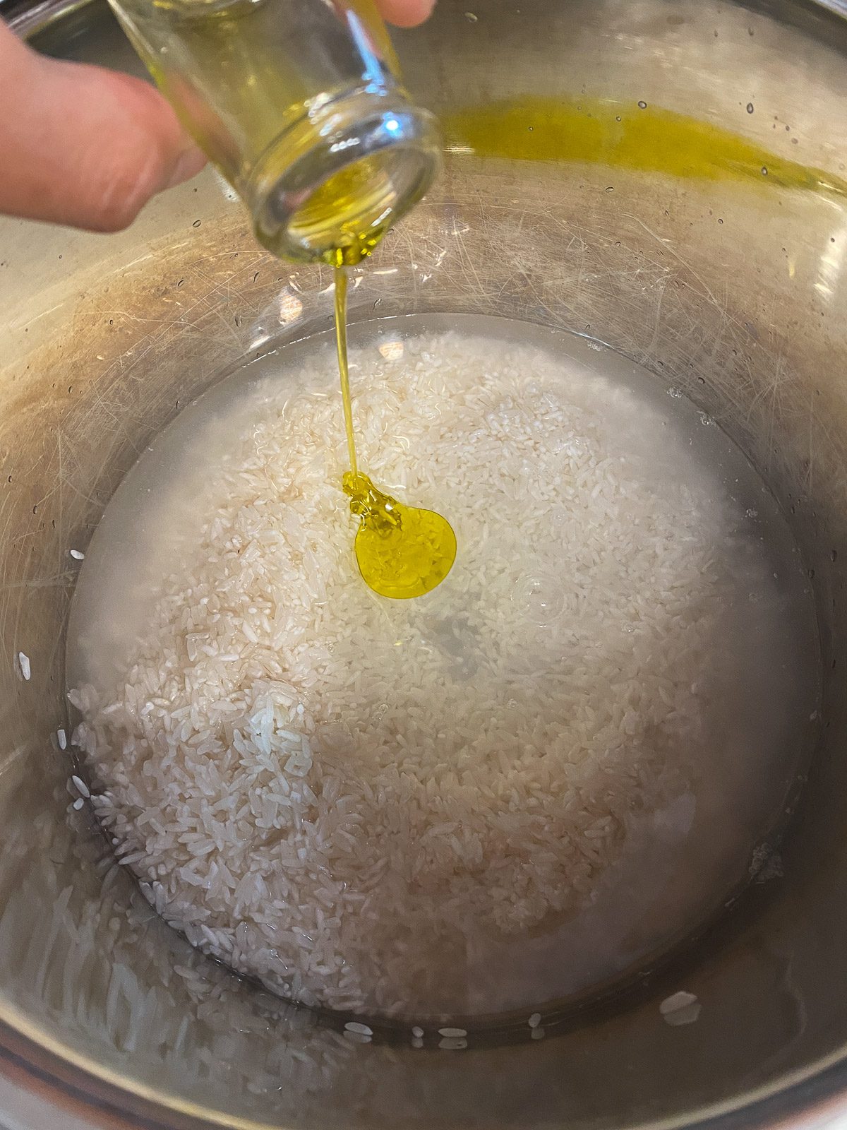 process shot of oil being added to rice in pot