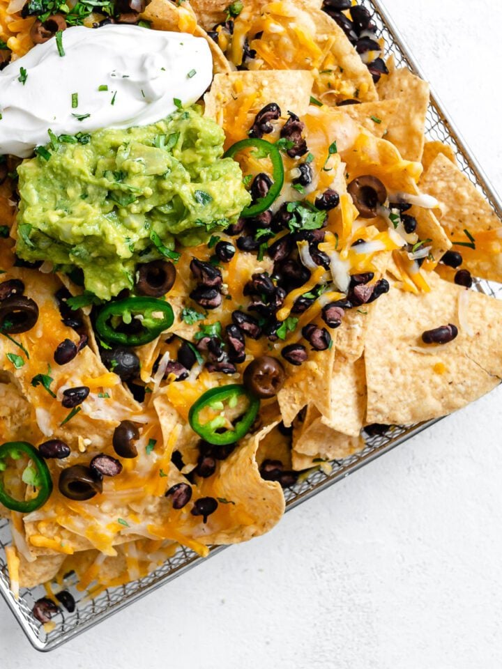 completed Vegan Air Fryer Nachos on air fryer tray against white surface