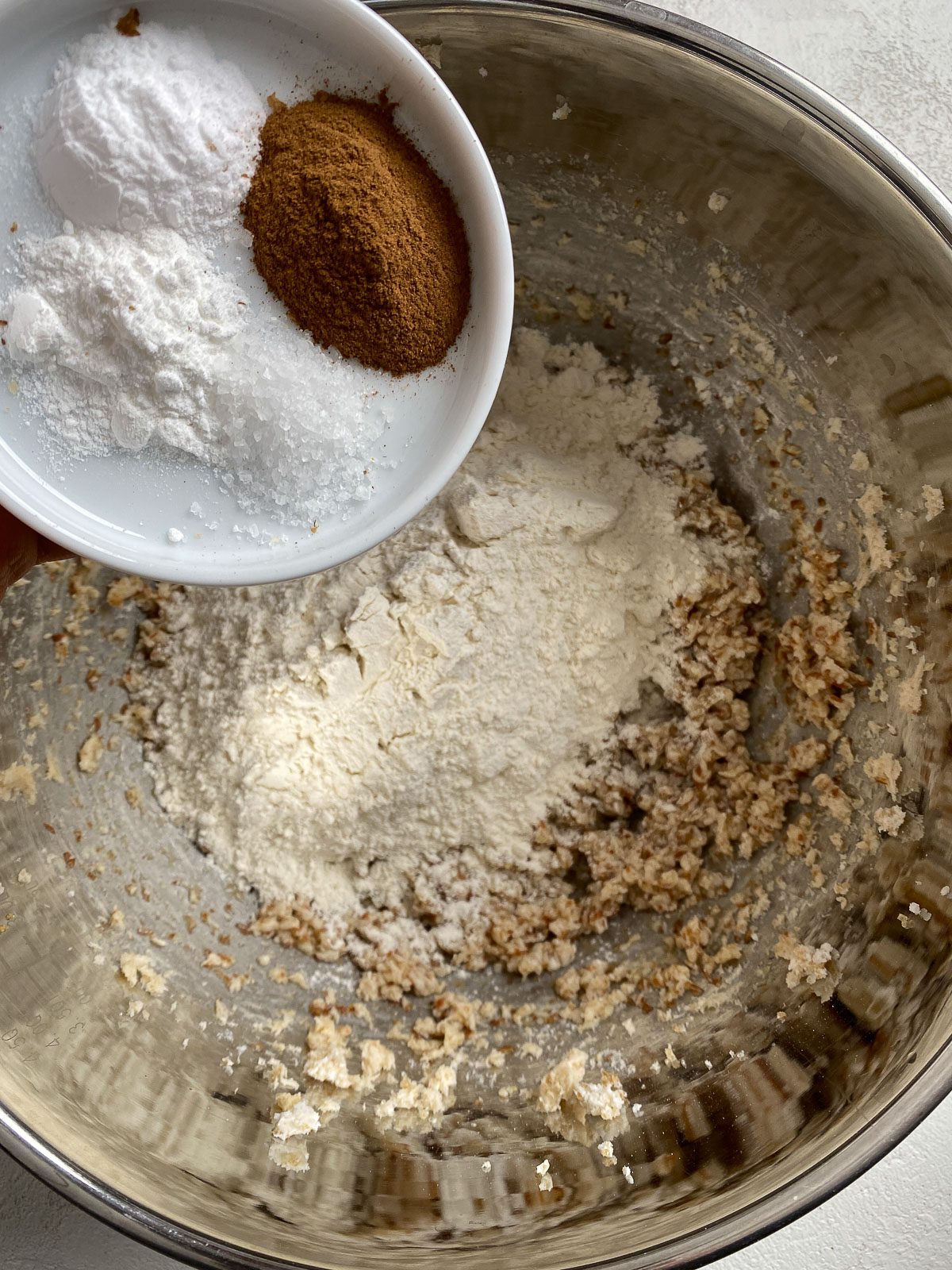 process of adding cinnamon, baking powder and baking soda to mixing bowl