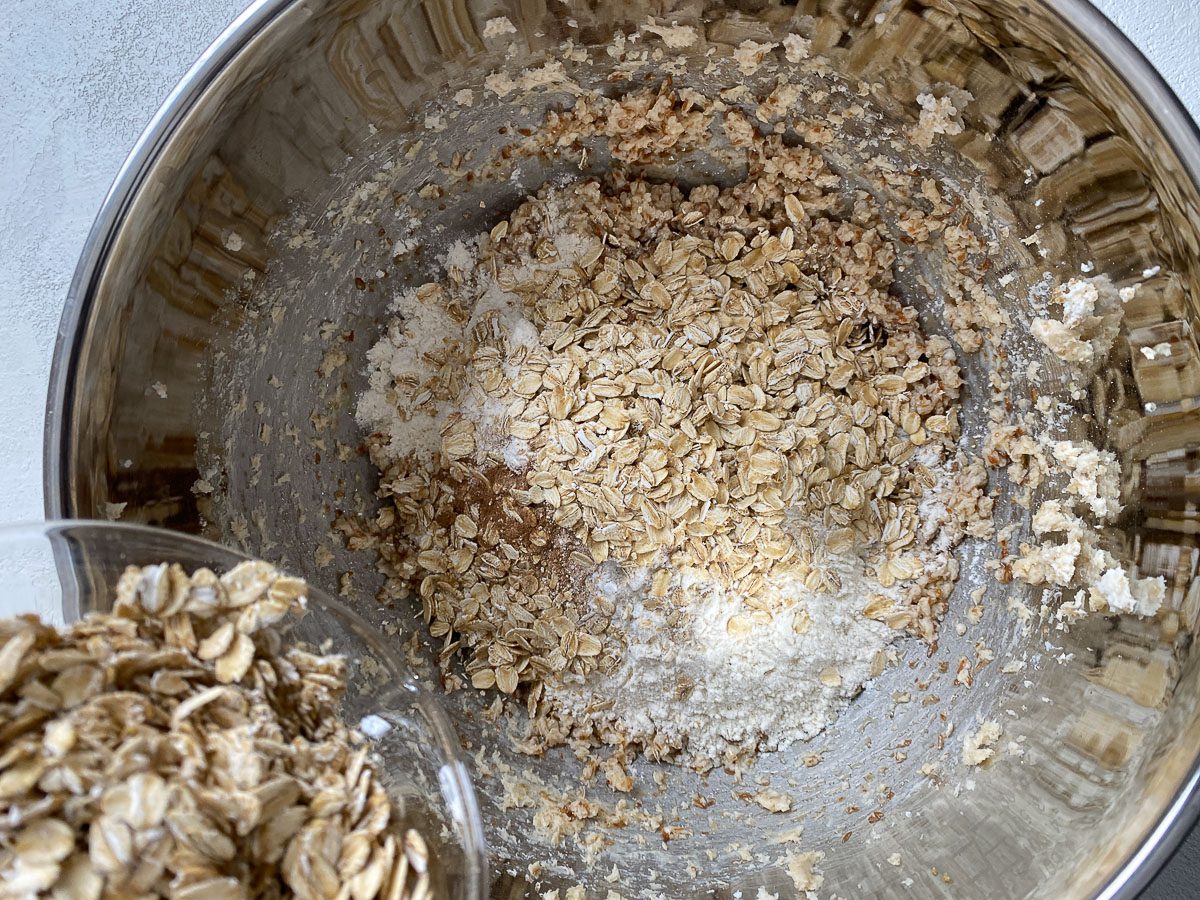 process shot of adding oatmeal to mixing bowl