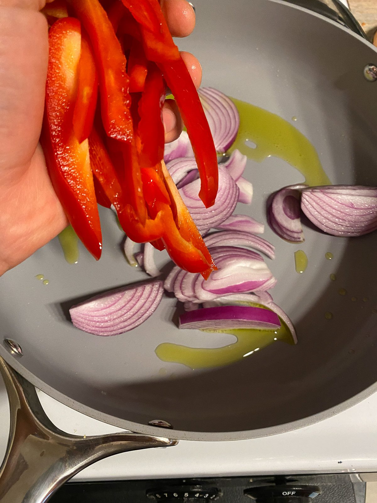 process of adding red peppers to skillet