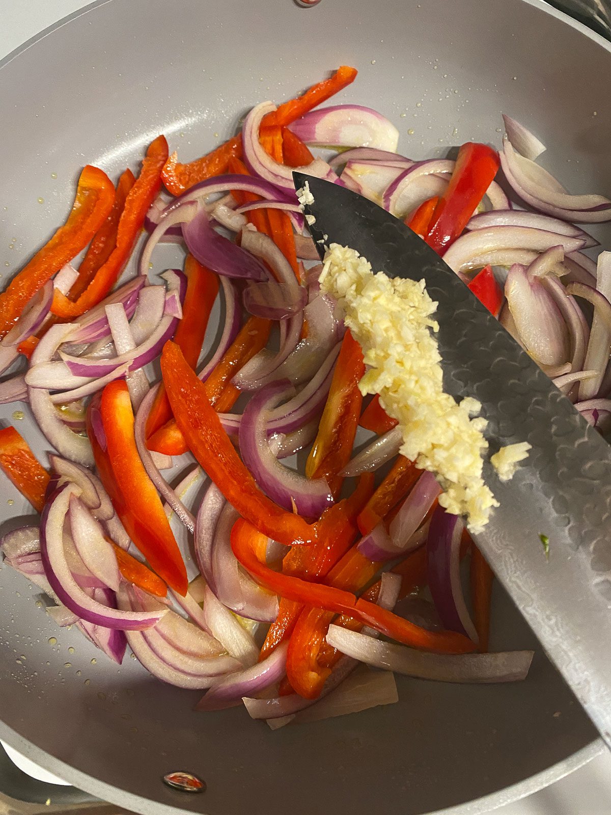 process of adding minced garlic to skillet