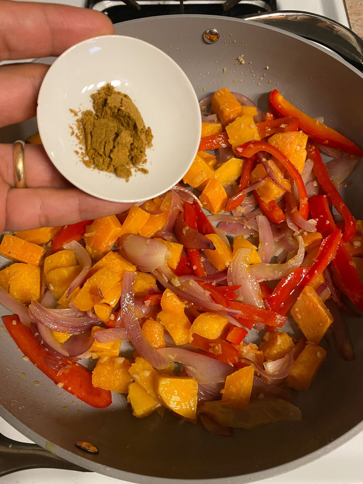 process of adding cumin to skillet