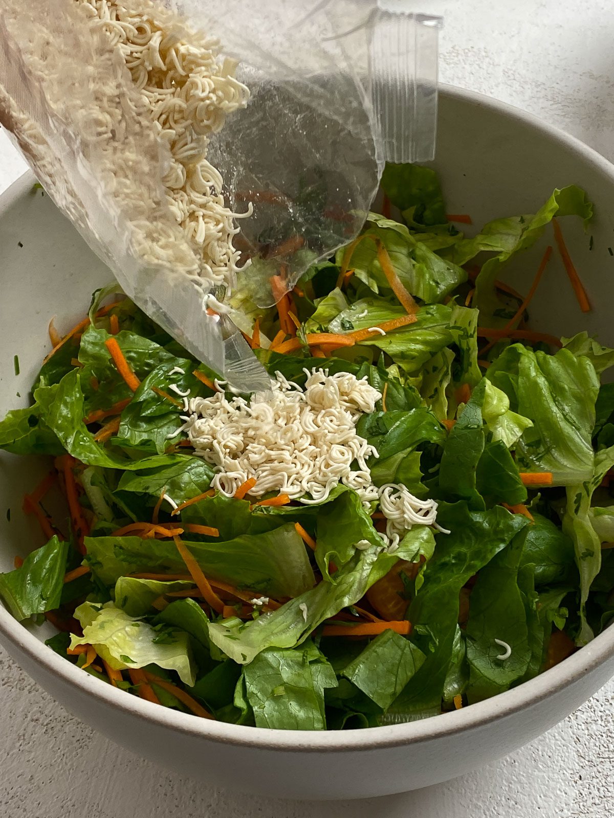 process of vegan ramen added to salad bowl
