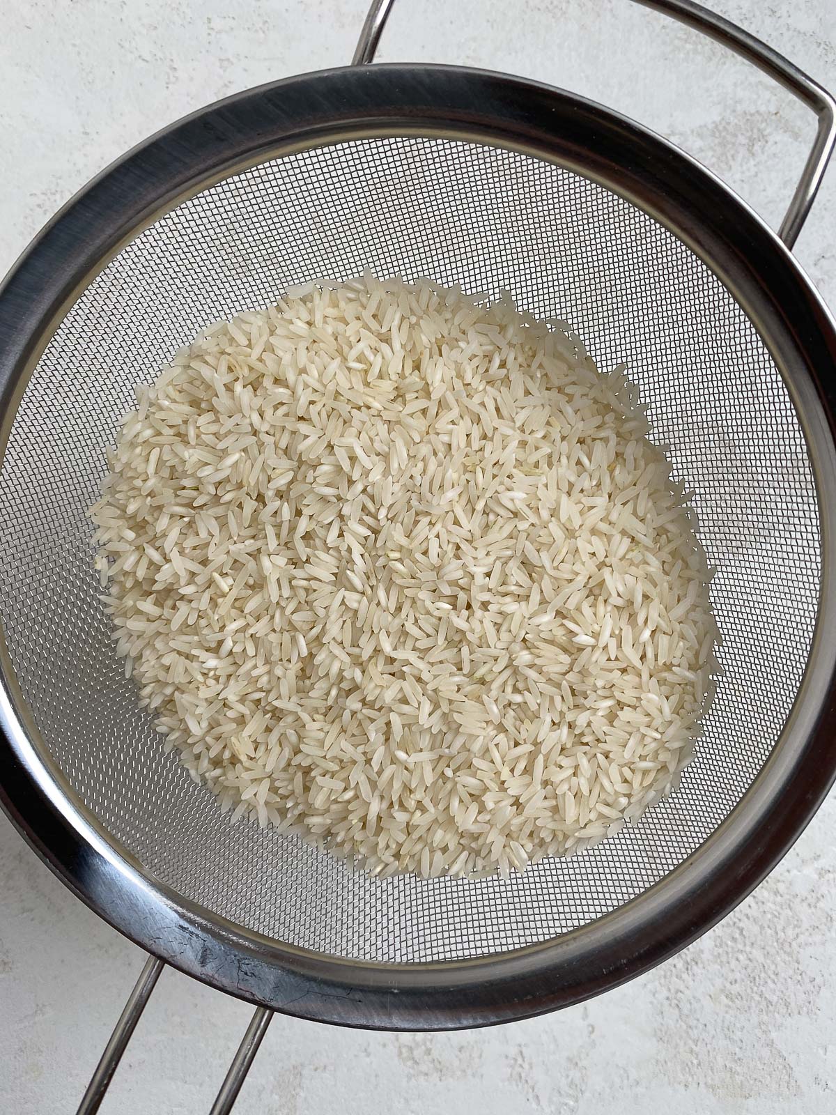 process of straining rice in collander