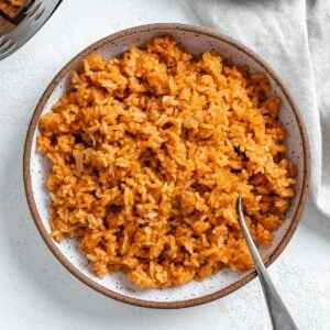 completed mexican rice in a white bowl against a white background