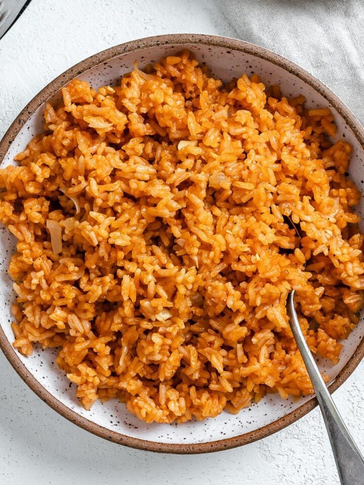 completed mexican rice in a white bowl against a white background