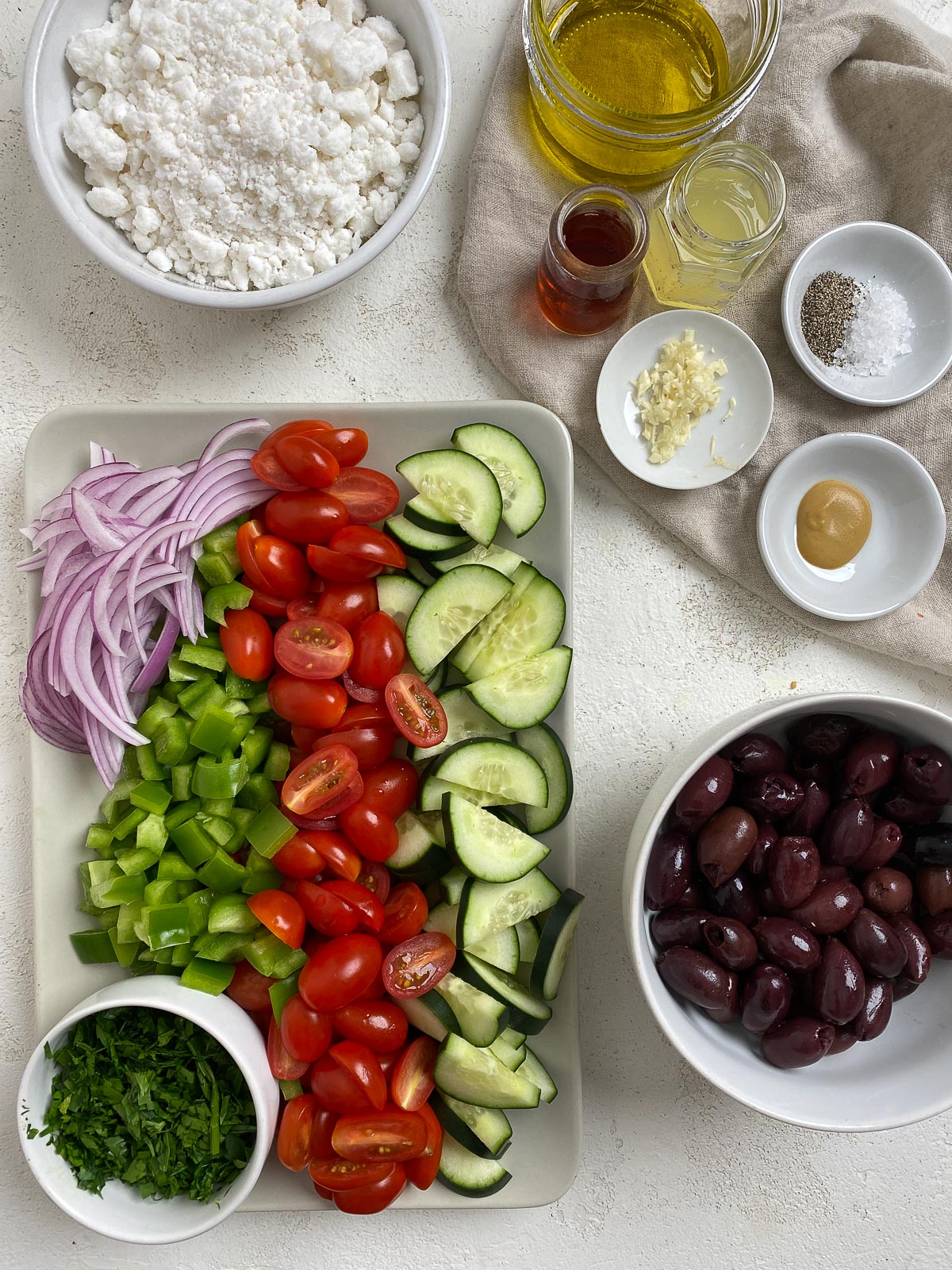 ingredients for Vegan Greek Salad measured out against a white surface