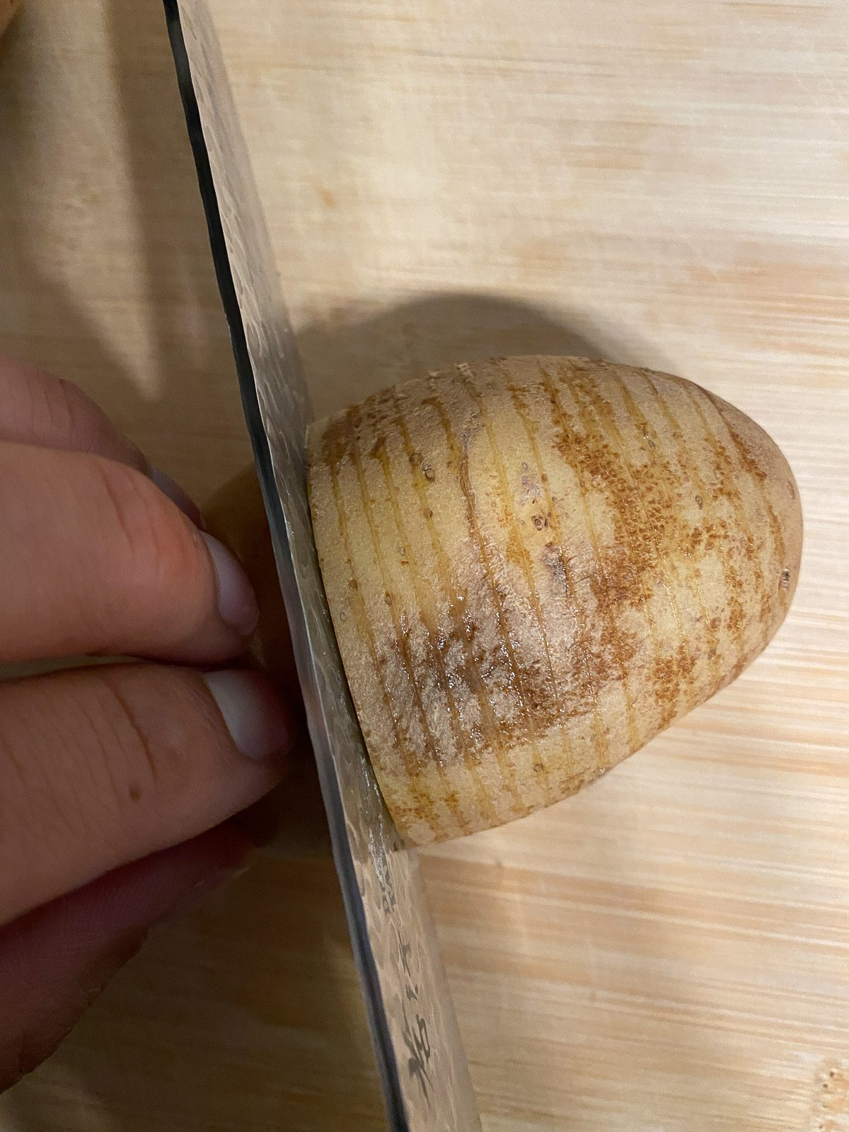 process of cutting potatoes for Vegan Hassleback Potatoes
