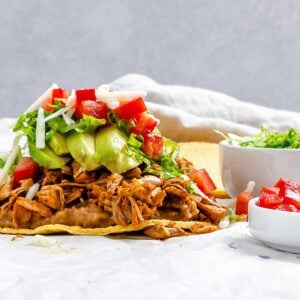 completed Vegan Jackfruit Tostadas on a white surface with veggies on the side