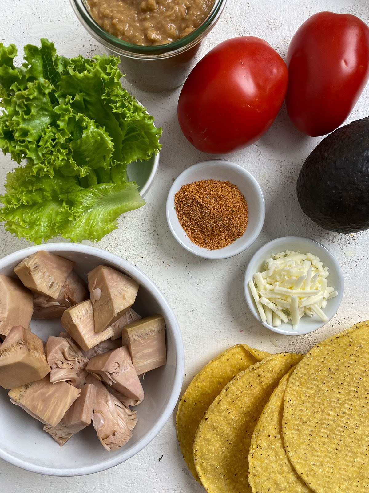 ingredients for Vegan Jackfruit Tostadas spread out on a white surface