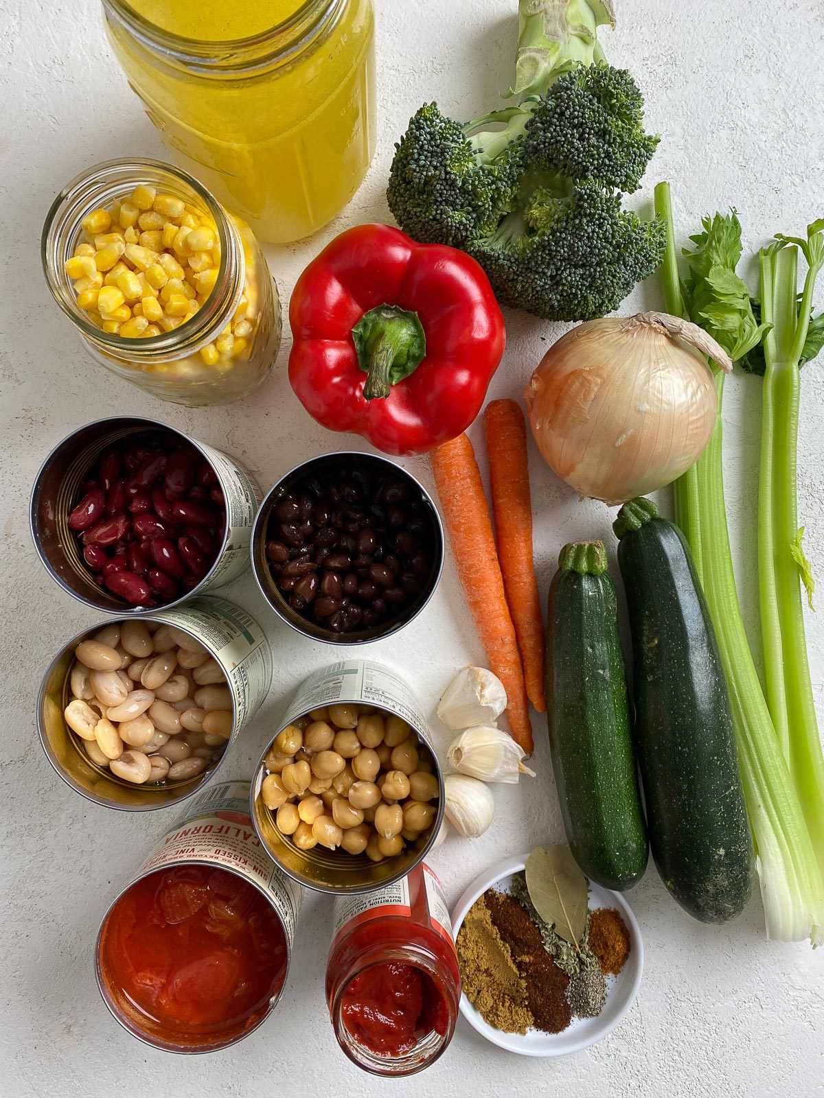 ingredients measured out for vegetable stew against a light surface