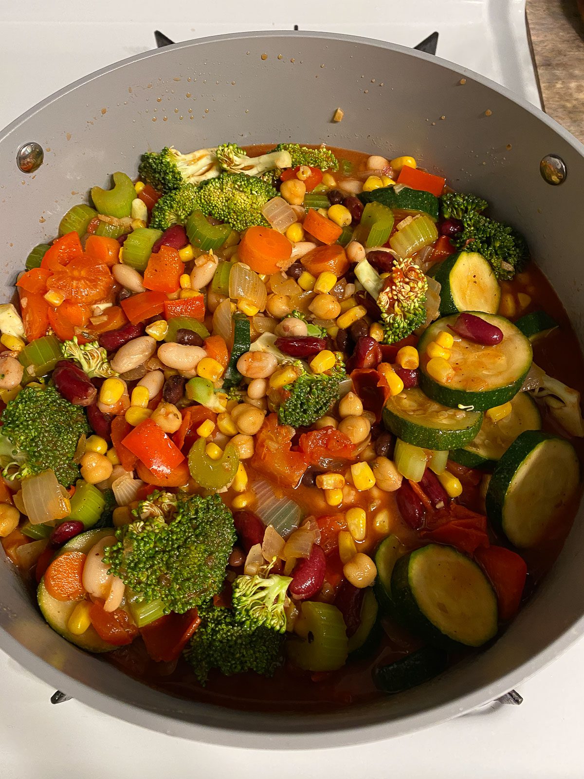 process of mixing mixed pan of veggies and spices together in a bowl