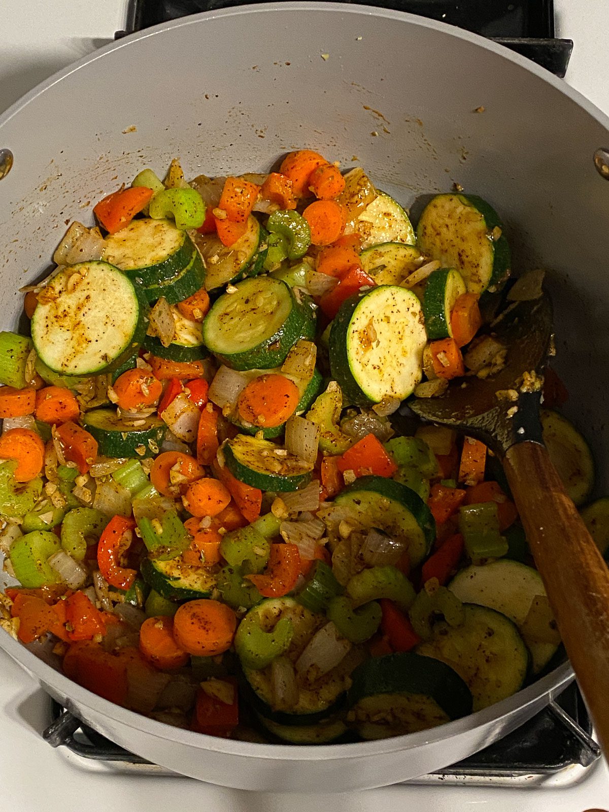 process of mixing veggies and spices in pan