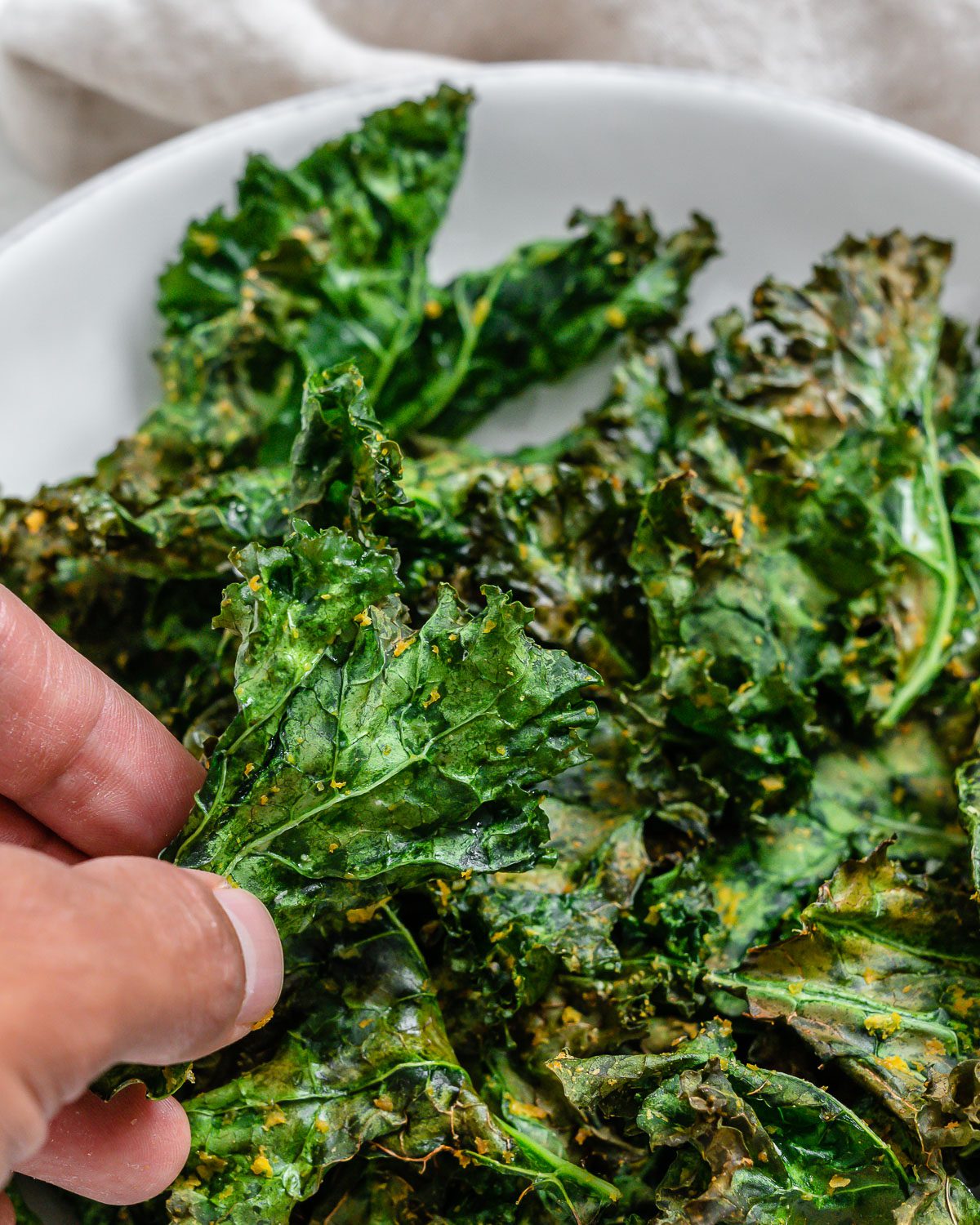 completed Air Fryer Kale Chips in a white bowl with close up shot