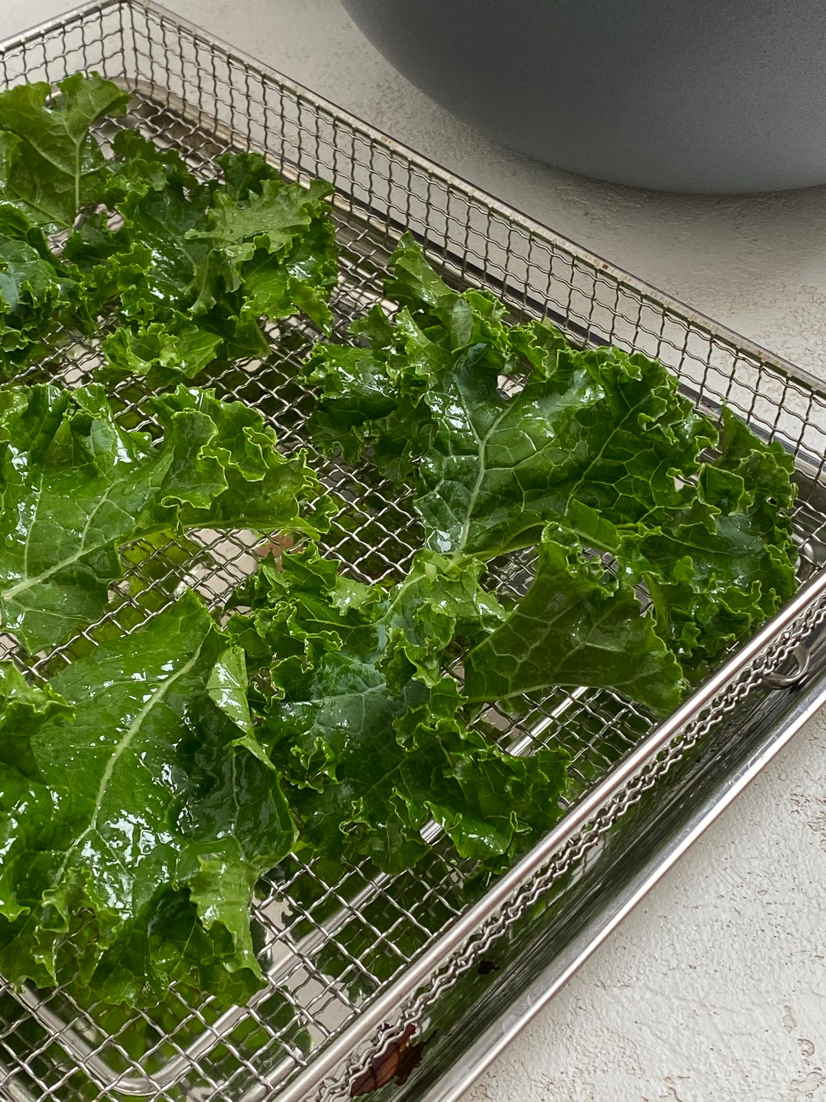 kale spread out on air fryer rack
