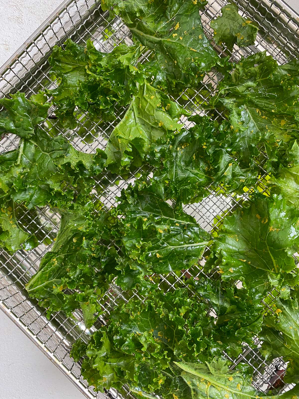 post addition of seasonings onto kale on rack