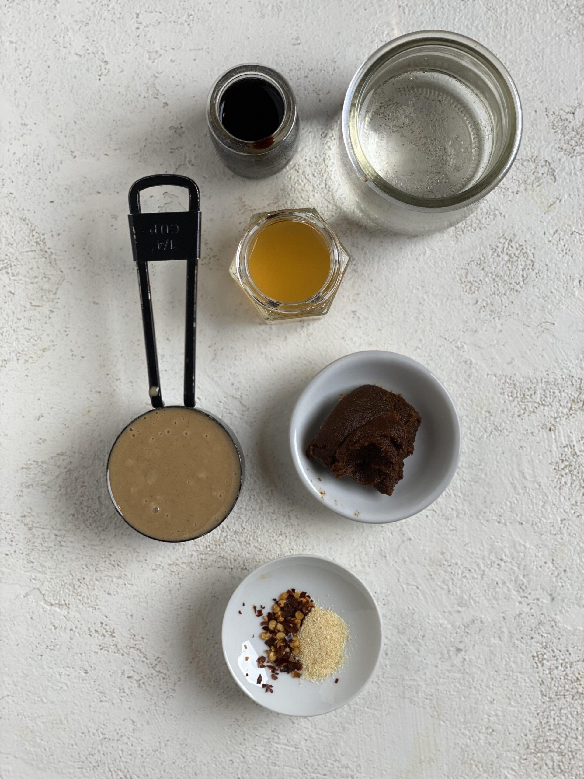 ingredients for Miso Tahini Dressing measured out against a light surface