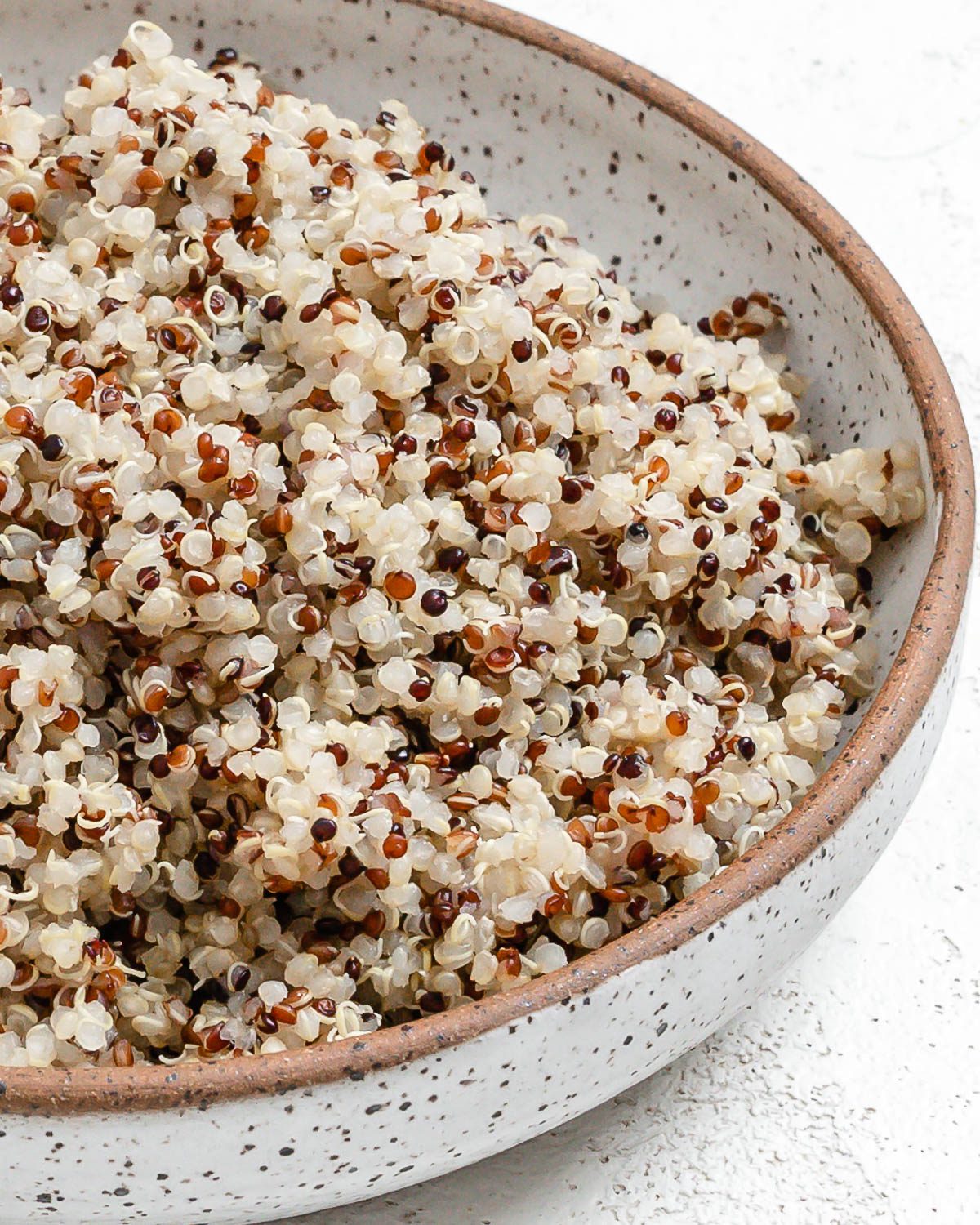 completed Pressure Cooker Quinoa in a white bowl against a white background