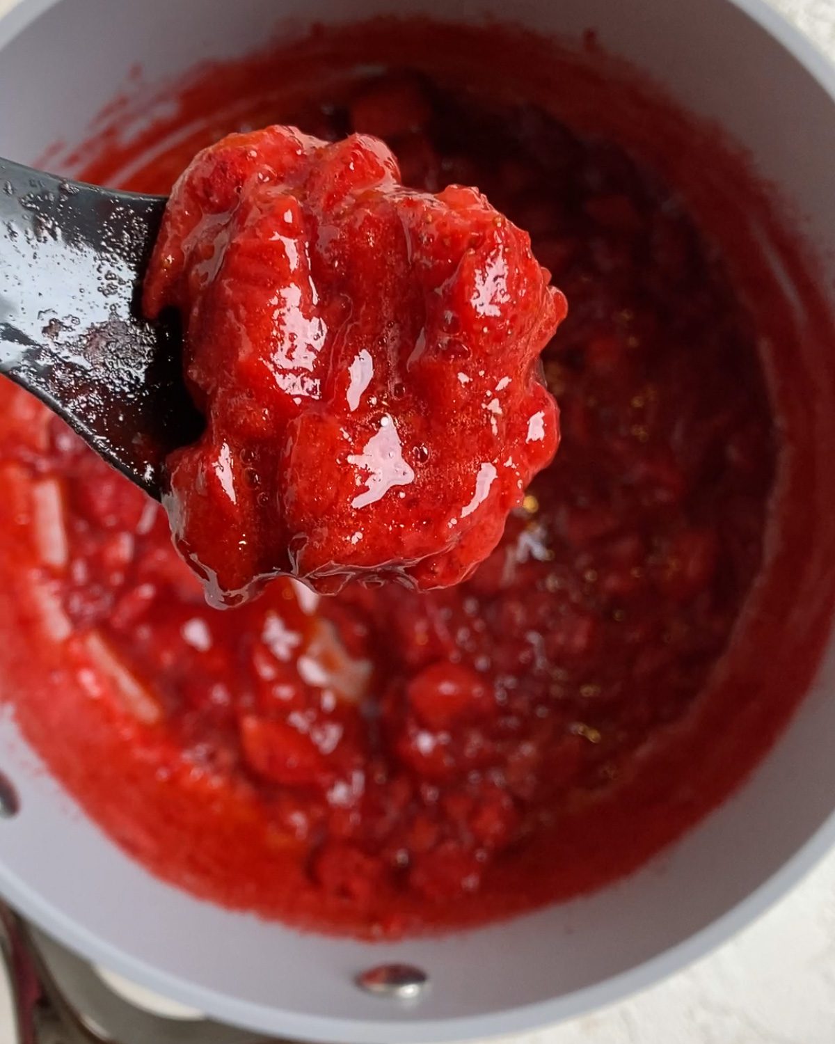 process of spooning strawberry compote in bowl