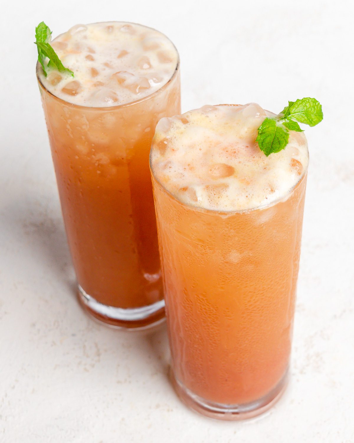 completed Strawberry Pineapple Mocktail in two glasses against a white surface